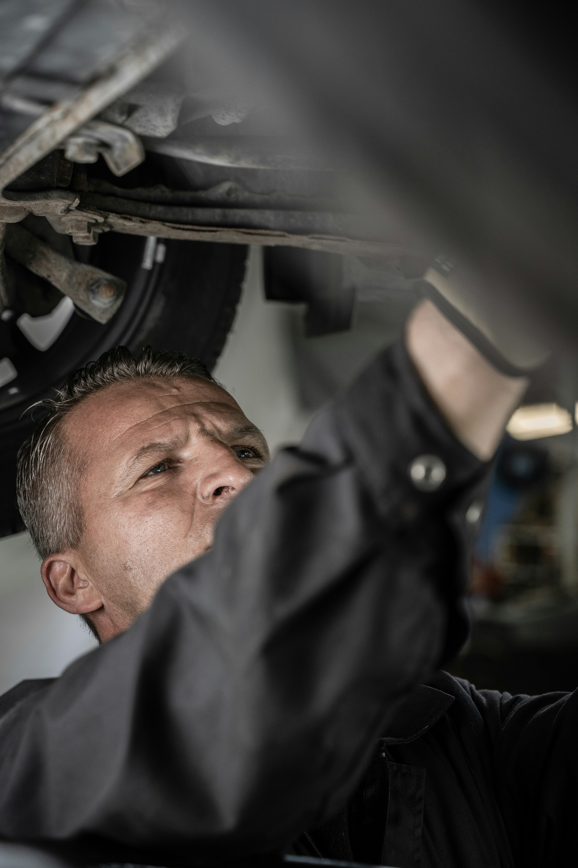 Mechaniker prüft das Fahrwerk von unten